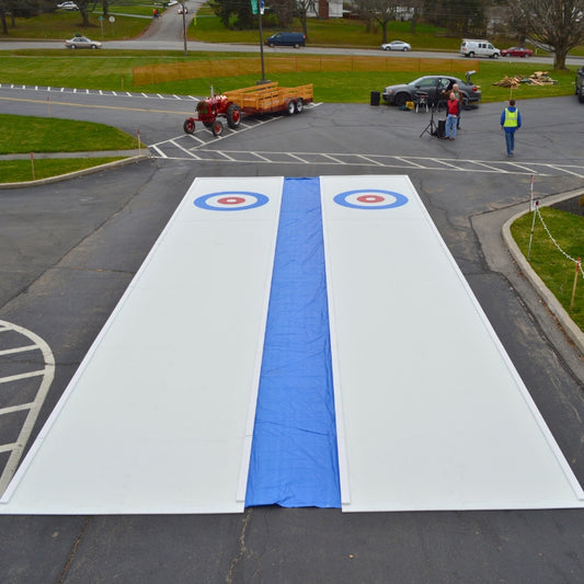 Aerial view of two mobile curling rinks setup in a parking lot before an event begins in Rochester, NY.