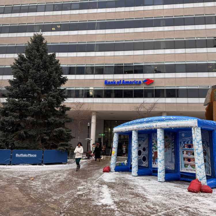 Winter Games 3 in 1 Inflatable rental setup outdoors in front of a big building next to a giant Christmas tree in Buffalo New York prior to a Winter Event starting.