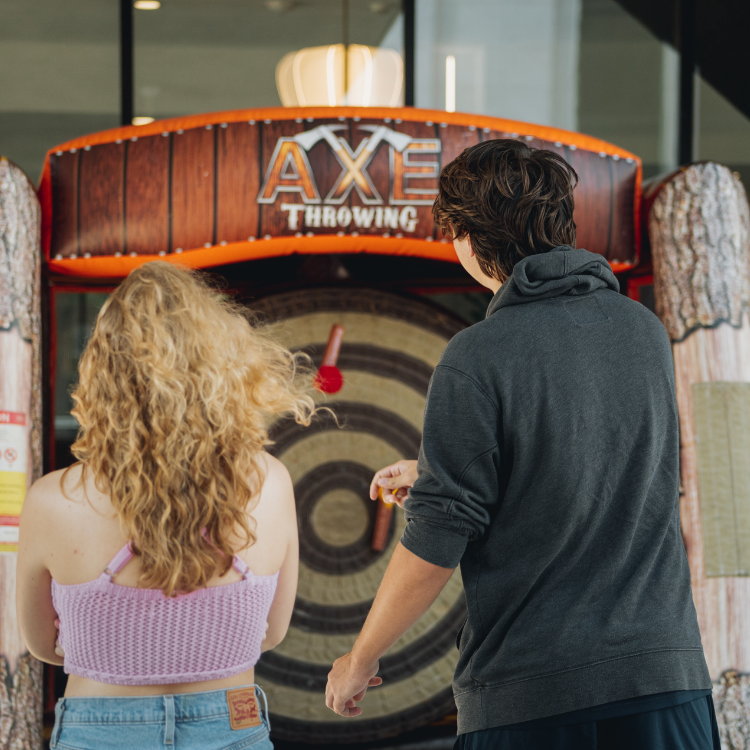 Two players throwing axes at the Inflatable Axe Throwing Game in Rochester, NY