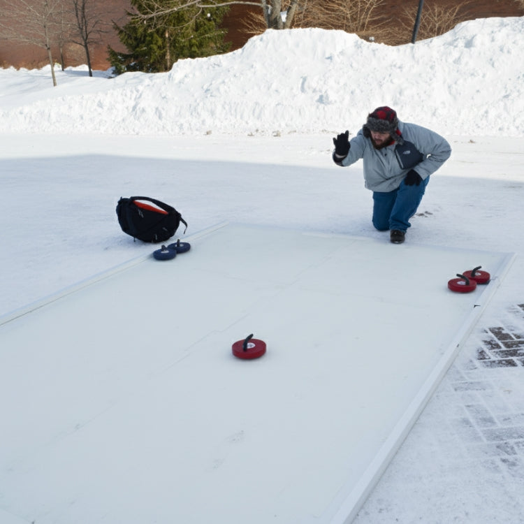 Person playing curling outdoors in Rochester, NY on a portable iceless rink with curling stones.