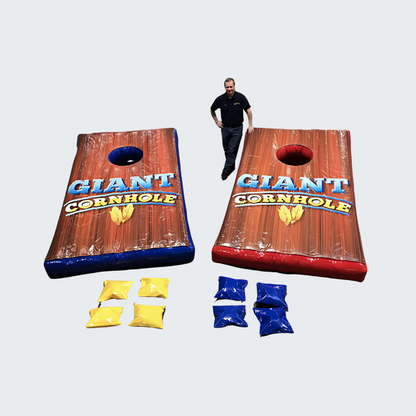 Man Standing Next to Giant Inflatable Cornhole Lawn Game Rental