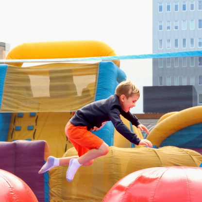 Boy Jumping From Ball to Ball on the Leaps & Bounds Inflatable Rental in Rochester, NY