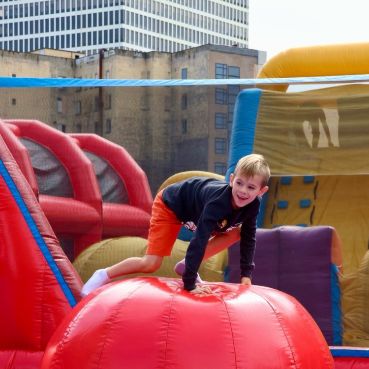 Boy Having Fun on The Leaps & Bounds Inflatable Rental at An Event in Rochester, NY