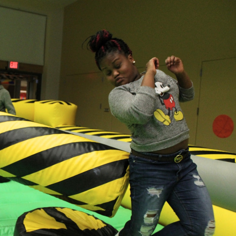 Girl Trying to Dodge the Meltdown Zone Mechanical Arm as Part of Inflatable Game Rental in Rochester, NY