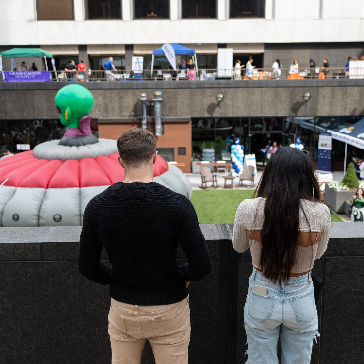 Two People Looking at the UFO Laser Tag Arena Inflatable at An Event in Rochester, NY